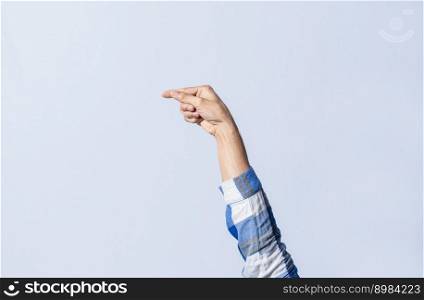 Hand gesturing the letter G in sign language on an isolated background. Man&rsquo;s hand gesturing the letter G of the alphabet isolated. Letters of the alphabet in sign language