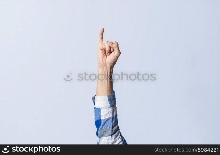 Hand gesturing the letter I in sign language on an isolated background. Man’s hand gesturing the letter I of the alphabet isolated. Letters of the alphabet in sign language