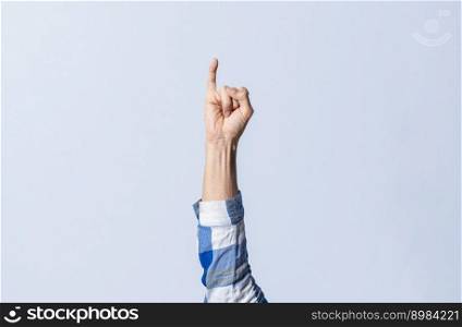 Hand gesturing the letter I in sign language on an isolated background. Man’s hand gesturing the letter I of the alphabet isolated. Letters of the alphabet in sign language