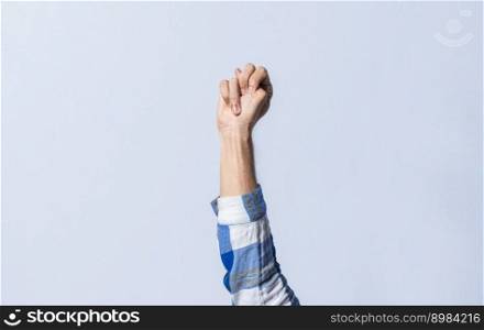 Hand gesturing the letter N in sign language on an isolated background. Man’s hand gesturing the letter N of the alphabet isolated. Letter N of the alphabet in sign language