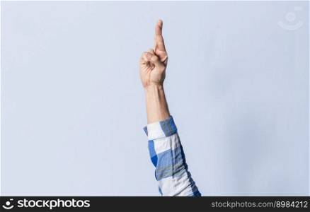 Hand gesturing the letter R in sign language on an isolated background. Man&rsquo;s hand gesturing the letter R of the alphabet isolated. Letter R of the alphabet in sign language