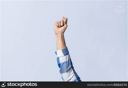 Hand gesturing the letter T in sign language on an isolated background. Man&rsquo;s hand gesturing the letter T of the alphabet isolated. Letter T of the alphabet in sign language