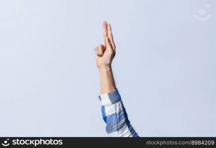 Hand gesturing the letter U in sign language on an isolated background. Man&rsquo;s hand gesturing the letter U of the alphabet isolated. Letter U of the alphabet in sign language