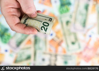 Hand giving money like bribe or tips isolated on banknotes background. EURO and USD currency banknotes close up. Reward for hard work, inflation, finance and business concept