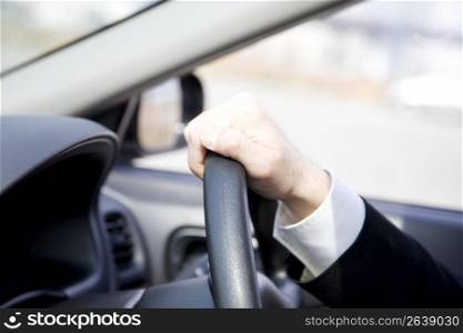 Hand gripping a steering wheel