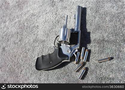 Hand gun and bullets on carpet