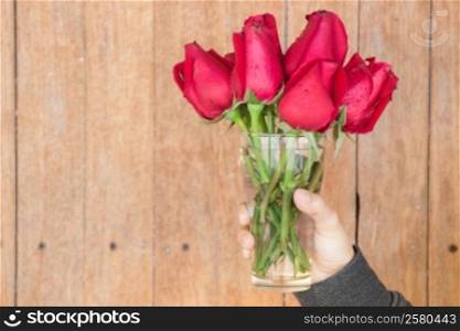 Hand hold glass of red rose, stock photo
