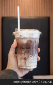 Hand hold ice mocha coffee in a glass with cream, stock photo