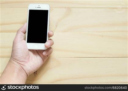 hand hold smartphone on the wooden bacground with screen clipping path include