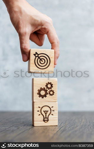 hand hold wood block with business goal, strategy, target, mission, action, objective, teamwork and idea concept