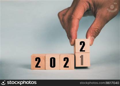 Hand hold wooden cubes 2021 and 2022 concept business change to new success