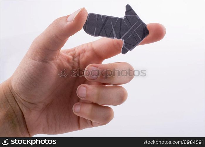 Hand holding a black arrow on a white background