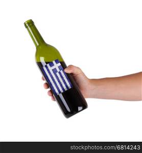 Hand holding a bottle of red wine, label of Greece, isolated on white,