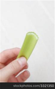 Hand holding a celery stick