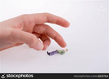 Hand holding a figure on a white background