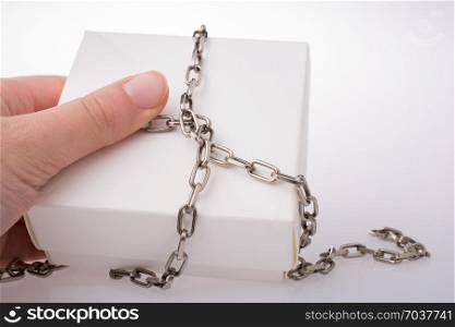 Hand holding a gift box with a chain around
