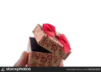 Hand holding a gift box with a red ribbon