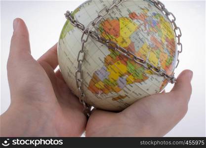 Hand holding a globe in chains