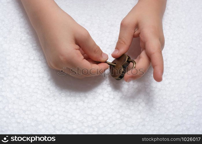 Hand holding a heart shaped lock and key on a white background