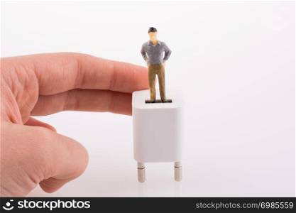 Hand holding a human figure on a white adapter
