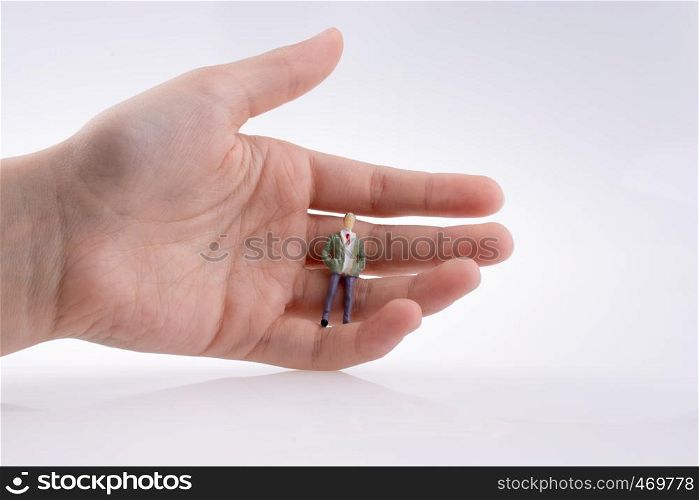 Hand holding a human figure on a white background