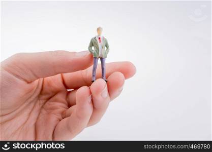 Hand holding a human figure on a white background