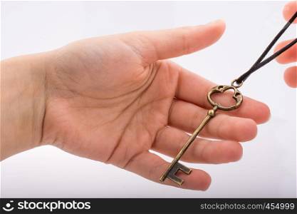 Hand holding a key on a white background