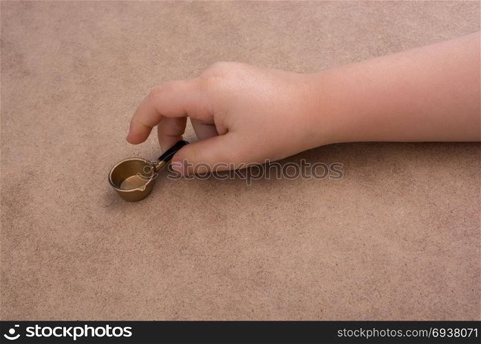 Hand holding a little model pan as a kitchen utensil