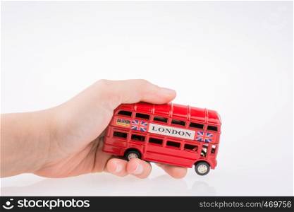 Hand holding a London Bus on a white background