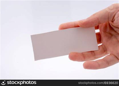 Hand holding a note paper on a white background