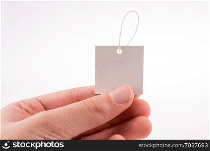 Hand holding a note paper with a holder on a white background