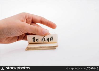 Hand holding a notebook with BE KIND wording