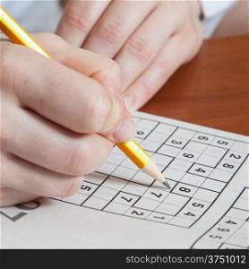Hand Holding a Pen Playing Sudoku