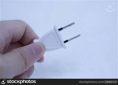 hand holding a plug