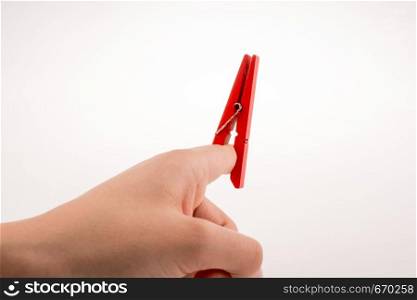Hand holding a red clothespin on a white background