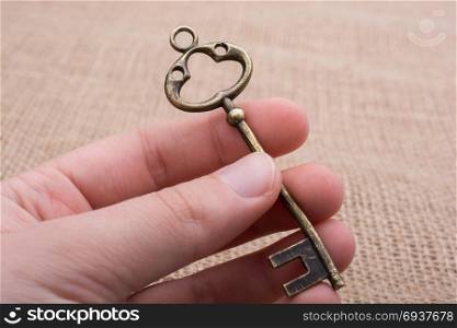 Hand holding a retro styled golden color decorative key