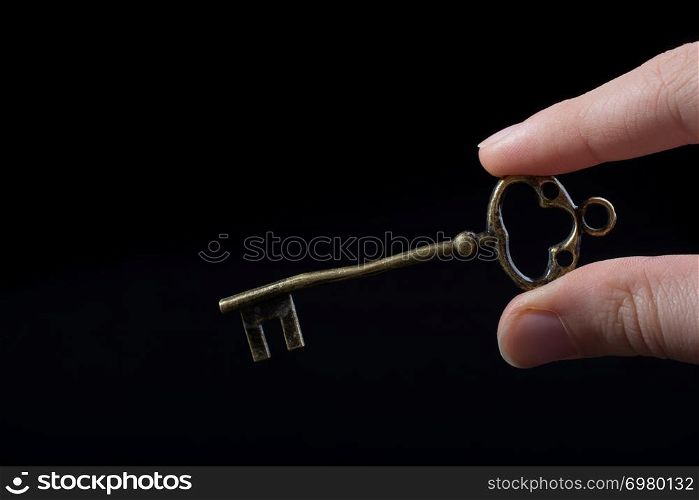 Hand holding a retro styled golden color decorative key