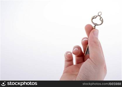 hand holding a retro styled metal key on a white background