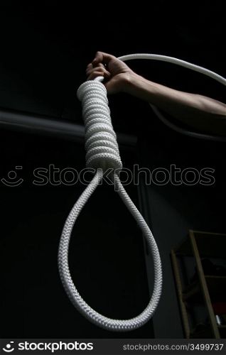 Hand holding a rope loop on black background