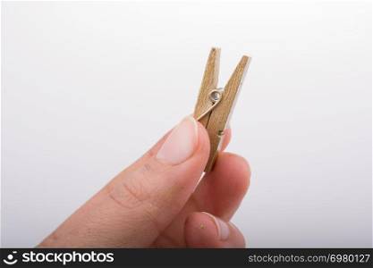 Hand holding a small wooden clothespin in hand