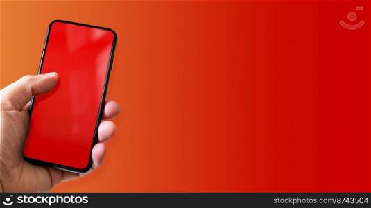 Hand holding a smartphone with blank red screen. Colorful background. Horizontal banner.. Hand holding a smartphone with blank red screen. Colorful horizontal banner.