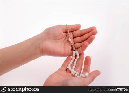 Hand holding a tespih on a white background
