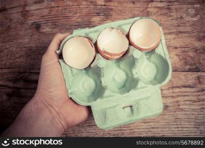Hand holding a tray of egg shells at a table