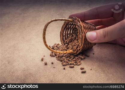 Hand holding a wicker basket on a canvas background