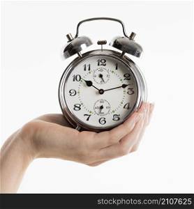 hand holding alarm clock