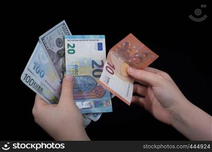 Hand holding American dollar banknotes isolated on black background