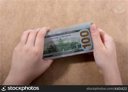 Hand holding American dollar banknotes isolated on wooden background