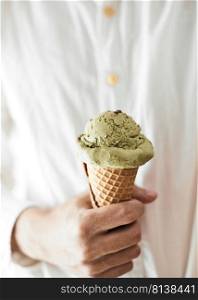 Hand holding an ice cream cone of green tea. . ice cream cone of green tea. 