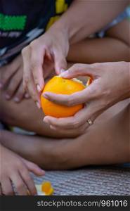 Hand holding an orange and peel.