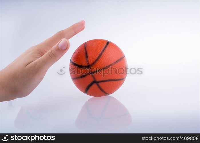 Hand holding an orange basketball model on a white background